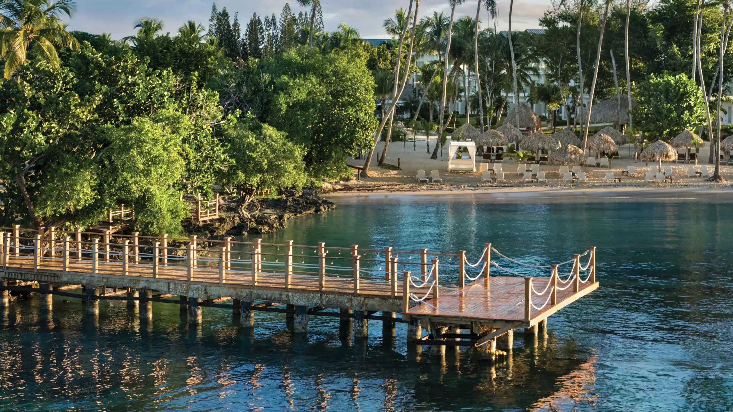 Scenic wooden pier overlooking calm Caribbean waters at Dreams La Romana Resort & Spa in Bayahibe.